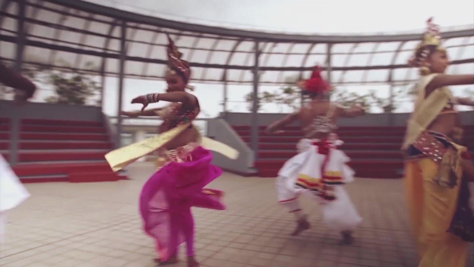 A Kandyan dancer mid-spin, a fire breather, and a devil mask in sparks