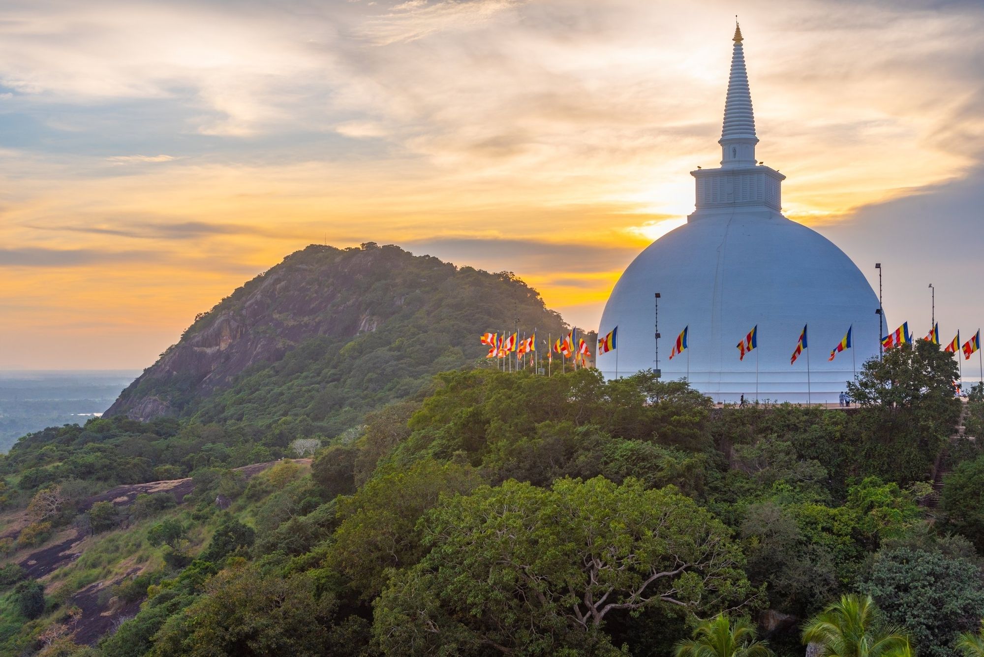 Mihintale's white stupa on the hilltop at sunset