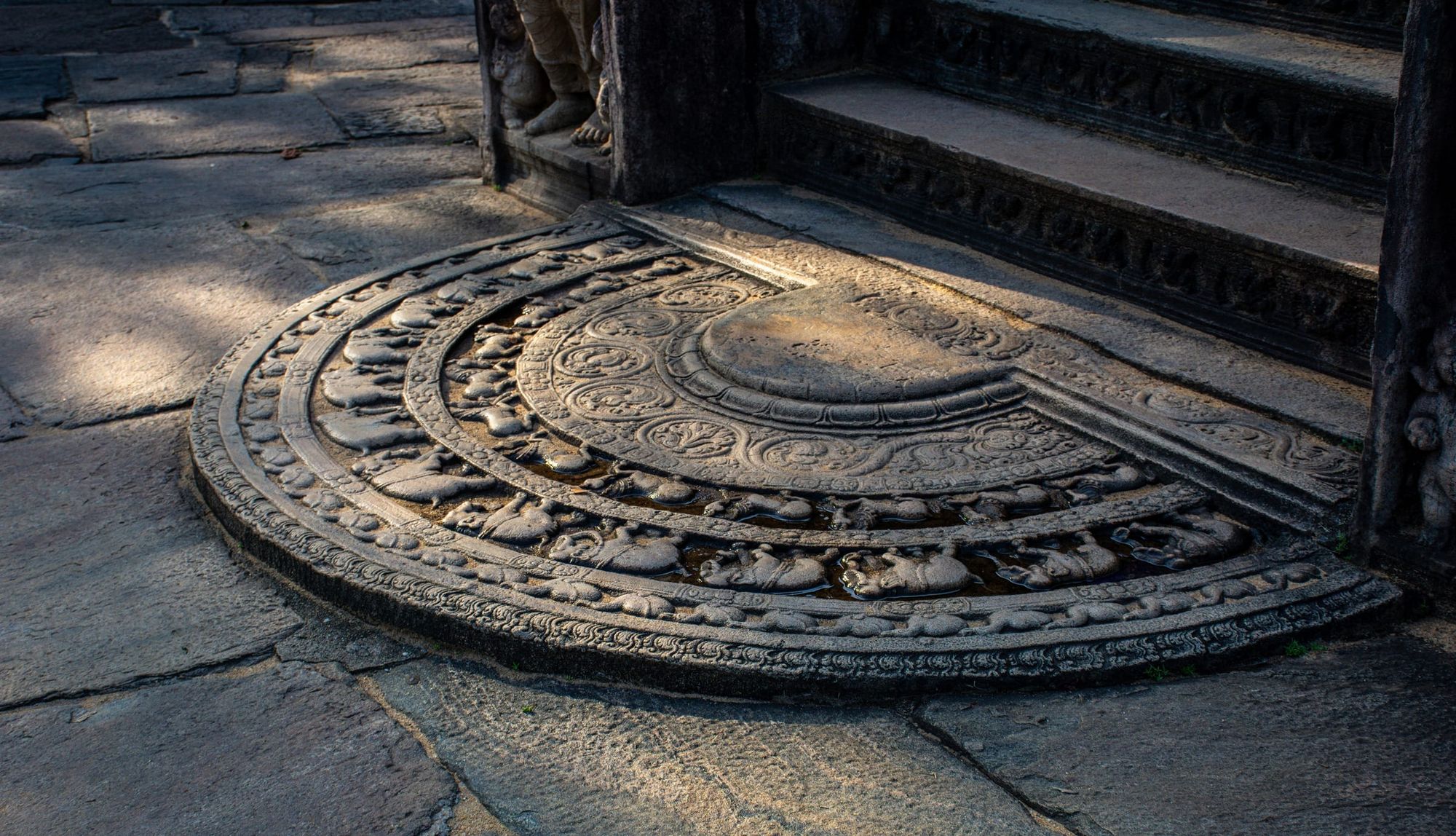 A carved stone moonstone at the foot of temple steps, Polonnaruwa