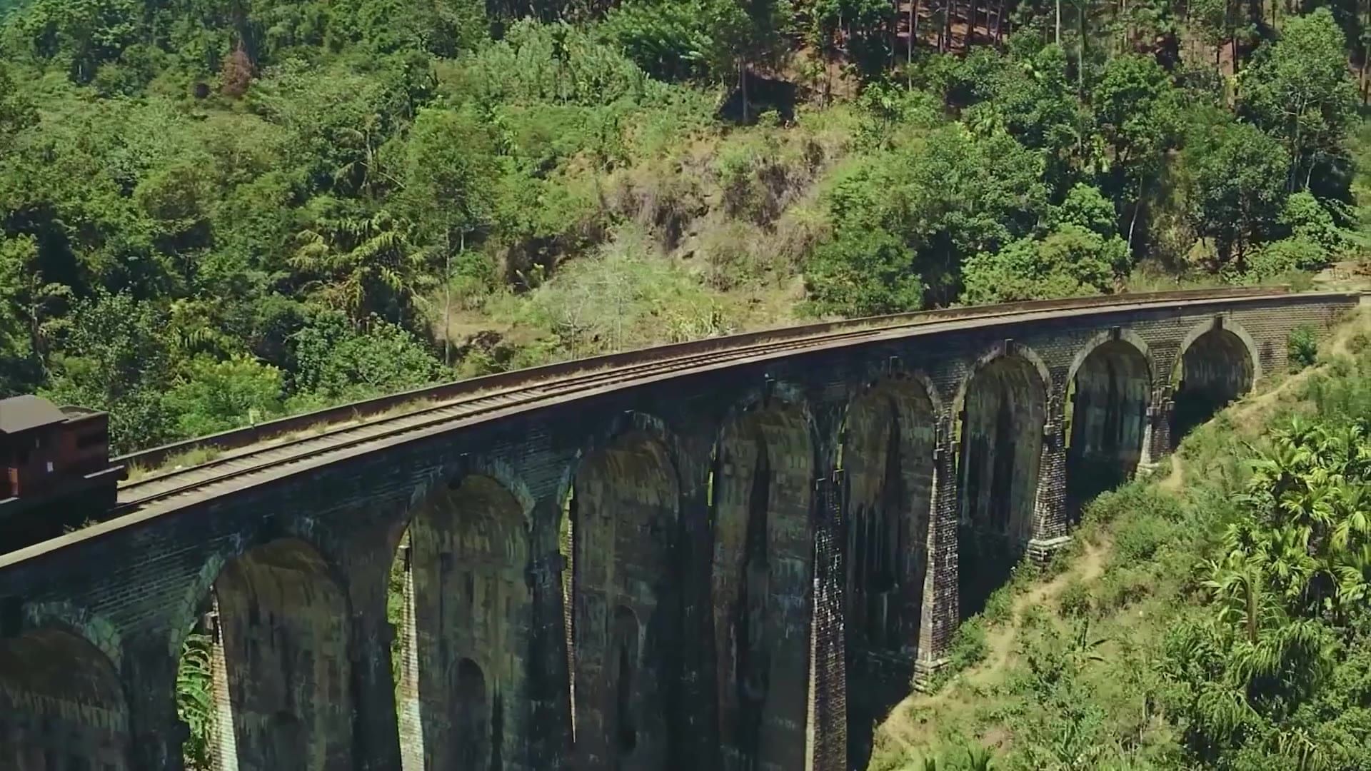 A blue train crossing the Nine Arch Bridge
