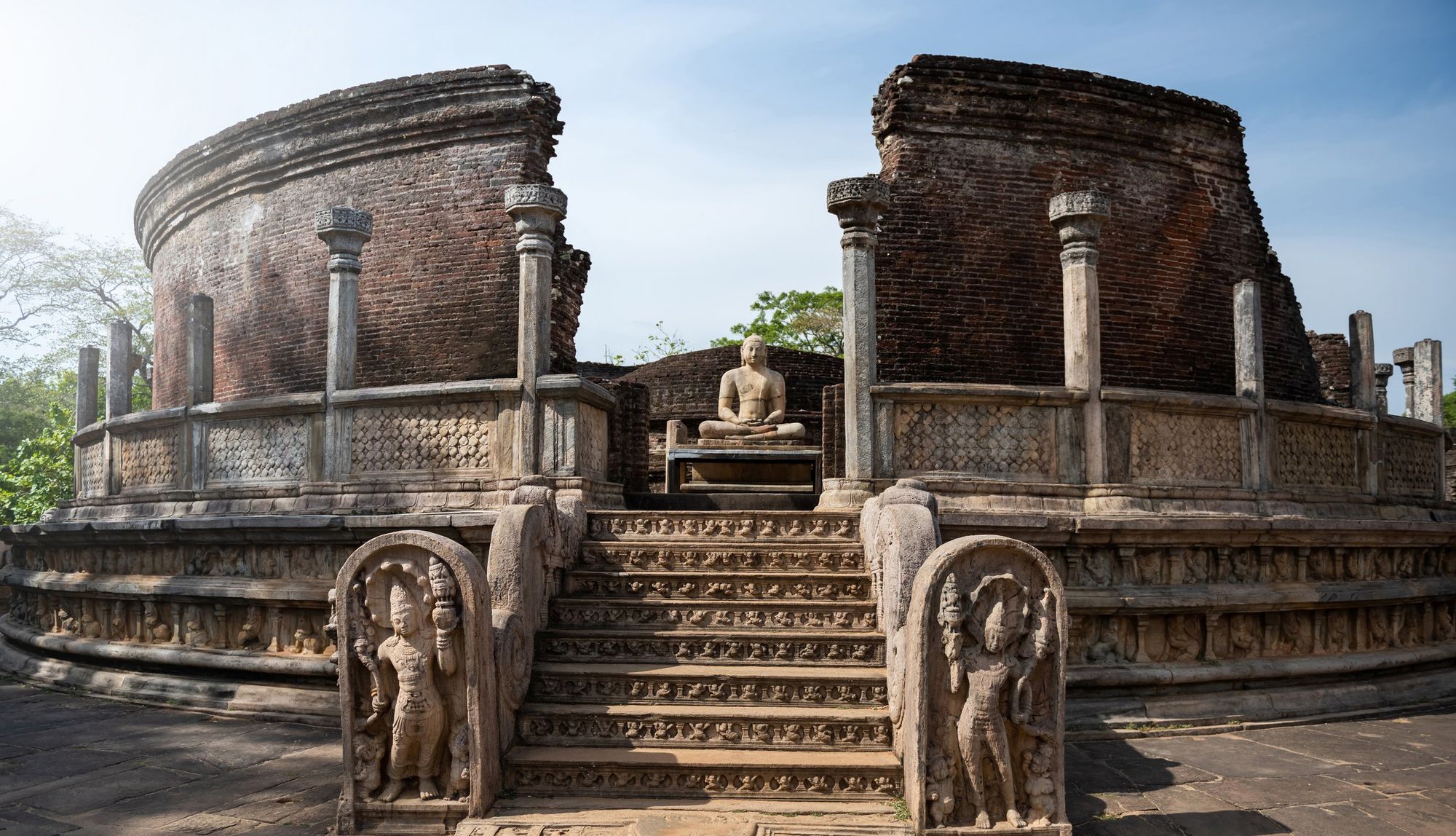 The round brick Vatadage at Polonnaruwa: carved guardstones flank the steps up to a seated Buddha