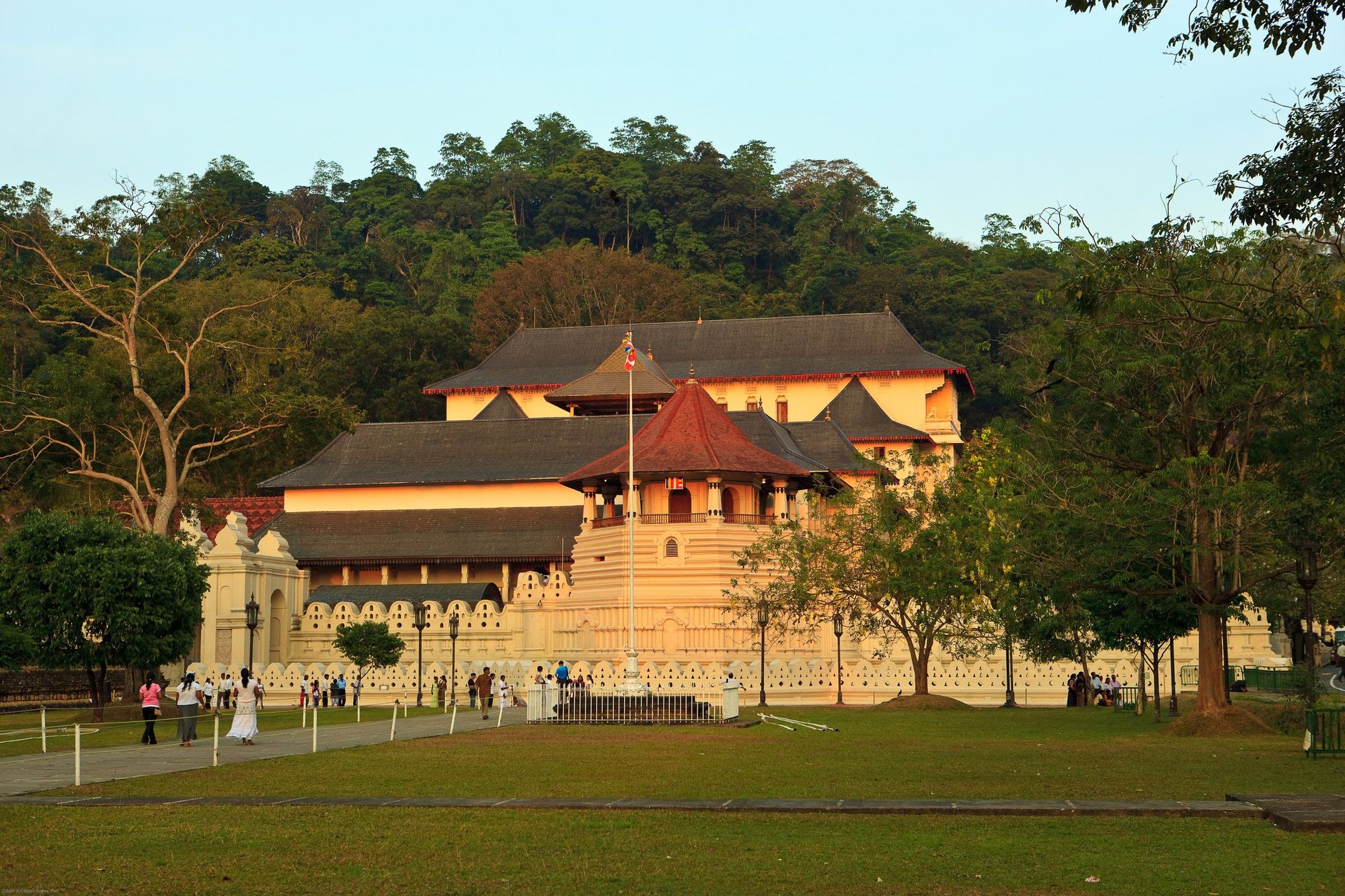 The Temple of the Tooth in Kandy in warm evening light, behind its lawn and white walls
